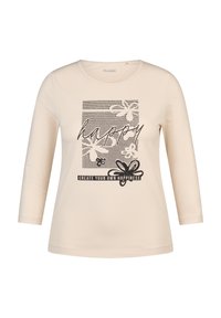 Helle cremefarbene Langarm-T-Shirt mit einem grafischen Design, das das Wort "happy", florale Muster und den Text "CREATE YOUR OWN HAPPINESS" in schwarz zeigt.