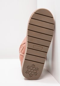 Růžová textilní podešev boty se strukturovaným povrchem s vodorovnými drážkami a vzorem sněhové vločky na patě. Velikost označena jako 37.