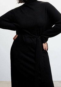 Robe longue noire en tissu doux, avec un col montant, des manches longues et un détail de taille nouée. Texture simple et lisse sans motifs.