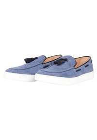 Le scarpe slip-on in suede blu hanno una suola bianca, dettagli neri e frange. Il design elegante include cuciture lungo i bordi.