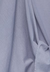 Tissu bleu clair avec une surface lisse et texturée, présentant des plis et des rides douces ; tissé avec des motifs subtils et des coutures soignées.