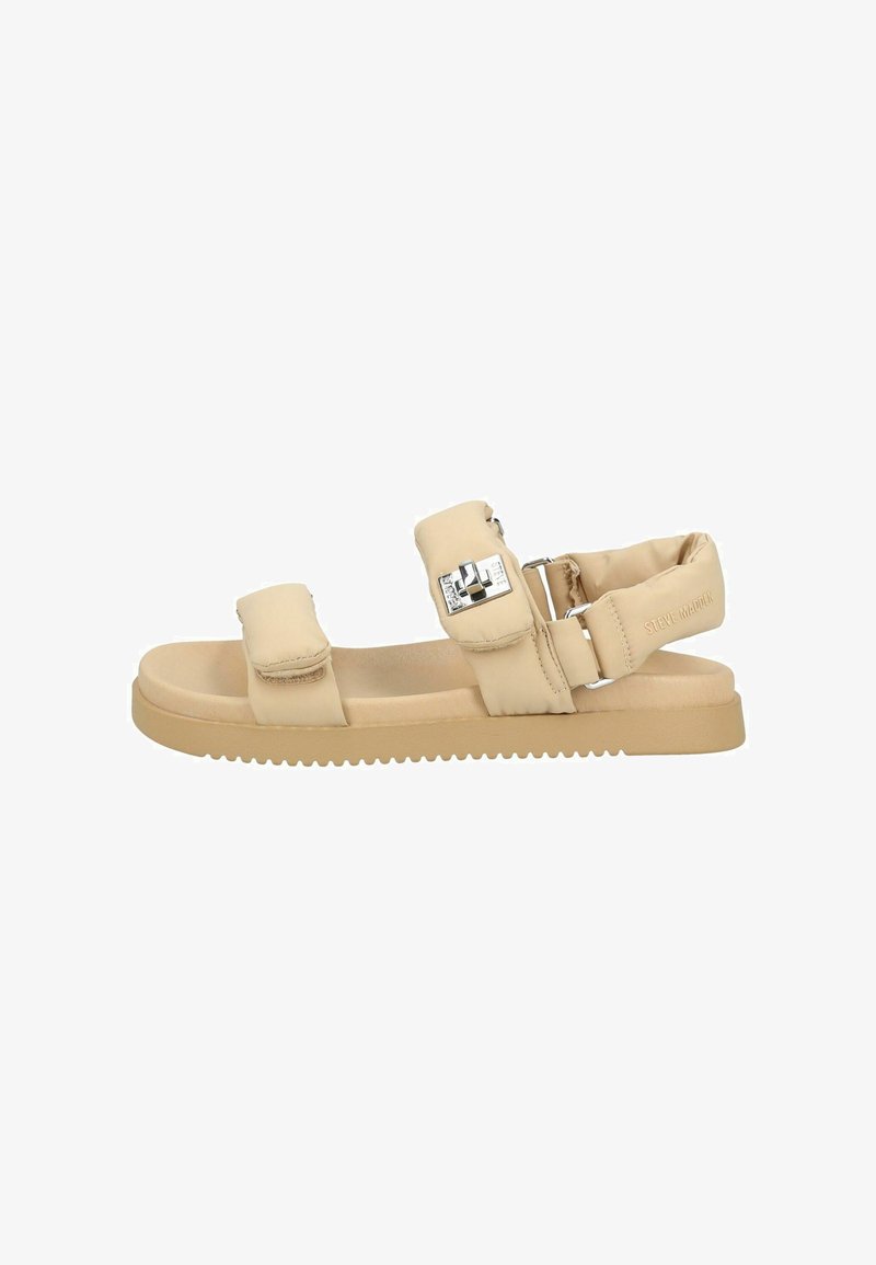 Sandalo piatto beige con due fasce imbottite in Velcro, una cinghia imbottita alla caviglia con fibbia in metallo e suola testurizzata, con marchio Steve Madden sul cinturino del tallone.