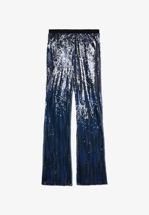 Spodnie z cekinami w fasonie dzwonów, w ciemnoniebieskiej palecie kolorów z srebrnymi akcentami, tworzące teksturowy efekt połysku.