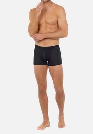Zwarte katoenen boxershorts met een strakke pasvorm, elastische tailleband en een voorkeiltje. Soepele textuur en geen zichtbare patronen of accenten.
