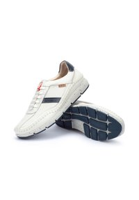 Sneaker in pelle bianca con accenti blu navy, design perforato, suola con imbottitura e cuciture a contrasto. Presenta una suola in gomma texturizzata.