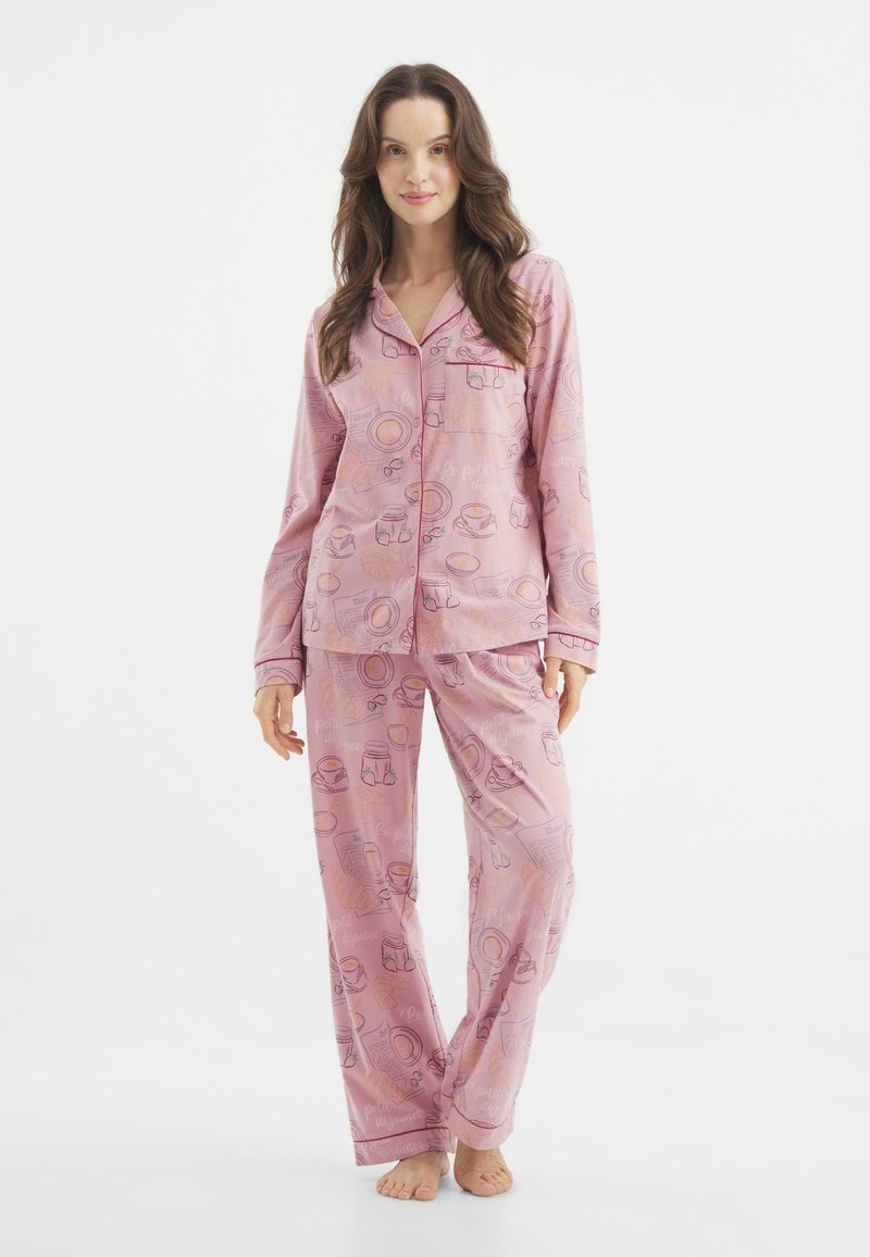 Rosa Schlafanzugset mit langen Ärmeln und Hose, das ein Printdesign von Nahrungsmitteln und Getränken in hellen Farben auf einem weichen, glatten Stoff zeigt.