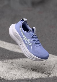 Light purple athletic shoe with a textured surface, white sole, and reflective accents. Features laces and a padded collar for comfort.