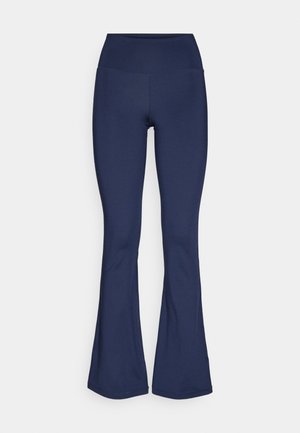 Leggings acampanados azul marino hechos de una tela elástica con una cintura alta, textura suave y sin patrones visibles ni detalles de hardware.