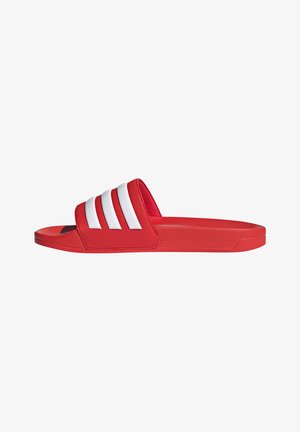 Red slide sandals made of synthetic material with a textured strap featuring three white stripes, flat sole, and rounded toe.