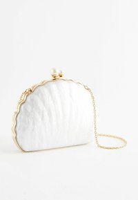 Pochette en forme de coquillage blanc avec une surface texturée, un bord ondulé doré et un fermoir en perle. Comprend une chaîne en or.