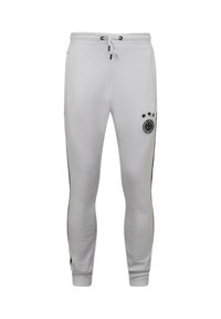 Witte joggerbroek met zwarte accenten, een taille met trekkoord en een logo met drie sterren op de linker bovenkant van het been. Glad materiaal, taps toelopende pasvorm.