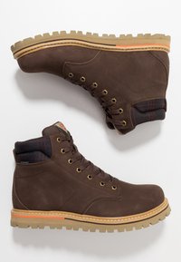 Ruske nahkasaappaat nauhoilla, joissa on kestävä kumipohja, kultaiset yksityiskohdat ja pehmustettu ruudullinen kaulus. Varustettu paksulla uralla pidon takaamiseksi.