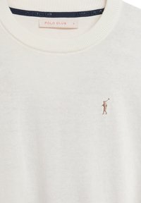 Pull en maille blanc avec col et poignets côtelés, arborant un petit logo figuratif brodé en beige sur la poitrine. L'étiquette indique "POLO CLUB".
