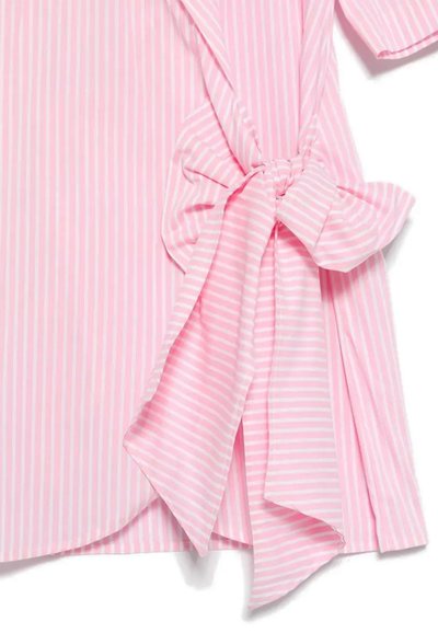 Chemise rayée rose et blanche avec un nœud noué à la taille. Elle a des manches courtes et un ourlet arrondi. Texture de tissu douce.