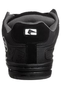 Black sneaker with a textured leather exterior, gray mesh collar, reinforced heel, and prominent brand logo on the side.