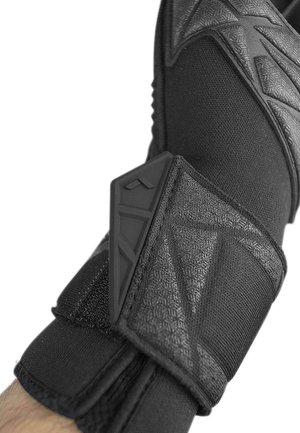 Guanto sportivo nero con tessuto testurizzato, un cinturino rinforzato per il polso e un accento in plastica nera sagomata sul polso per supporto.