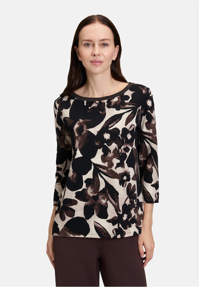 Schwarz- crèmefarbenes Oberteil mit floralem Muster in Brauntönen, mit Dreiviertelärmeln und Rundhalsausschnitt. Weicher, strukturierten Stoff.