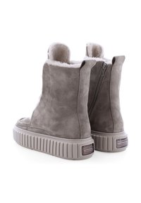 Graue Wildleder-Stiefeletten mit Kunstfellfutter, seitlichem Reißverschluss und einer strukturierten, massiven Sohle. Mit einem Logo-Akzent an der Ferse.