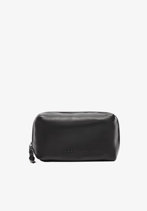 Pochette cosmetica in pelle nera con forma rotonda, texture liscia e logo del brand impresso sul davanti. Chiusura con cerniera nella parte superiore.