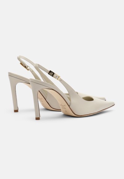 Paar beige Leder Slingback-Pumps mit spitzer Zehenpartie, schlanken Stilettoshäften und goldfarbenen Schnallenriemen auf weißem Hintergrund.
