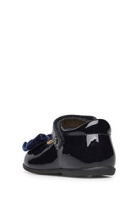 Granatowy but z lakierowanej skóry z miękką detalem z zamszu w postaci kokardy. Posiada zapięcie na pasek i okrągły czubek.