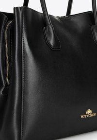 Borsa a mano in pelle nera con design strutturato, texture liscia, hardware in tonalità oro e dettaglio del marchio nella parte anteriore inferiore.