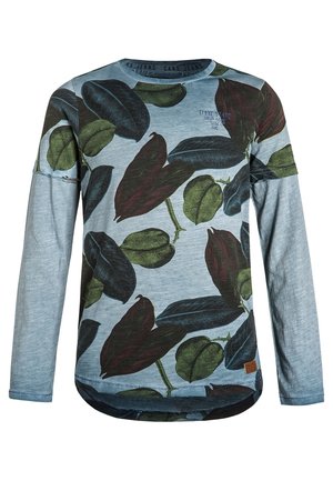 Lyseblå langærmet skjorte med store grønne og mørkerøde bladmønstre og en lille brun logo-patch ved nederste kant.