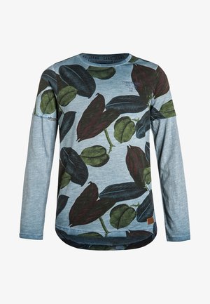 Camicia azzurra a maniche lunghe con grandi motivi di foglie verdi e rosso scuro e una piccola toppa marrone con il logo nell'orlo inferiore.