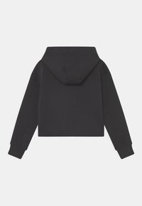 Sudadera negra recortada con mangas largas y una gran capucha adjunta, vista desde atrás sobre un fondo blanco.