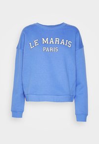 Sudadera azul corta con mangas largas, con un texto blanco que dice "LE MARAIS PARIS" en la parte delantera. Tela suave con un dobladillo acanalado.