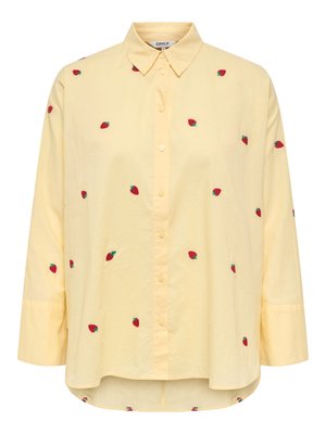 Šviesiai geltona ilgomis rankovėmis palaidinė su sagutėmis ir apykakle, dekoruota mažais raudonais braškių raštais, išsibarsčiusiais ant audinio.