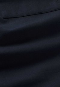 Marineblaue Stoff, glatte Textur, leichter Glanz, mit einer horizontalen Naht und einer einzelnen Taschen-Details. Weiches, gewebtes Materialmuster.