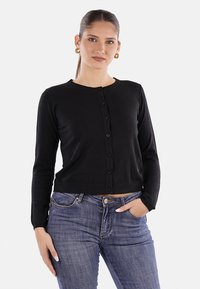 Cardigan nero con maniche lunghe, scollo rotondo e chiusura a bottone. Realizzato in un tessuto testurizzato, presenta un design cropped.