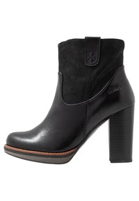 Zwarte enkelboot van een combinatie van glad leder en suede, met een ronde neus, een blokhak en een trekloopje voor gemakkelijk aan- en uittrekken.