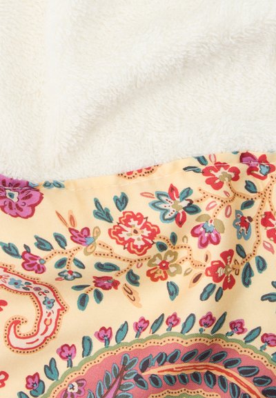 Tissu crème doux avec des motifs floraux et cachemire colorés en rouge, violet, bleu et vert sur fond jaune.