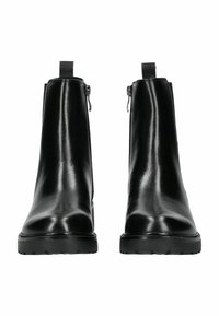 Par de botas de cuero negro hasta el tobillo con cremalleras laterales y suelas de goma gruesa, vistas desde el frente sobre un fondo blanco.