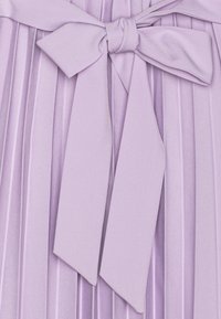 Lawendowa tkanina plisowana z szeroką, związaną kokardą na środku, prezentująca miękką teksturę i delikatne fałdy.