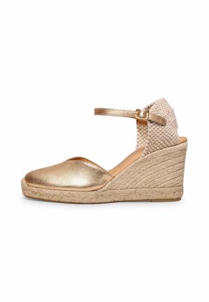 Sandalia de cuña espadrile con puntera cerrada metálica dorada, contrafuerte de talón tejido, correa en el tobillo y plataforma de yute trenzado.