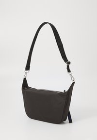 Borsa a spalla in nylon nero con forma curvata, chiusura con zip e tracolla regolabile con logo "HUGO" testurizzato. Accenti in metallo argentato.