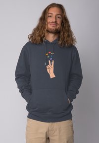 Marineblauwe hoodie met een afbeelding van een hand die een vredesteken maakt, versierd met gekleurde hartjes erboven. Zachte stof, kangoeroezak.
