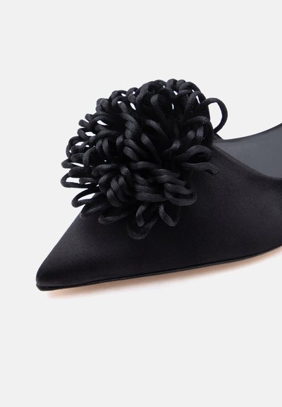 Μαύρο λεπτό επίπεδο παπούτσι με μυτερό δάχτυλο και μεγάλο υφασμάτινο διακοσμητικό βρόχο με υφή στο μπροστινό πάνω μέρος.