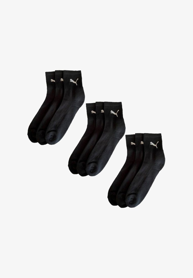 Drei Sets von drei schwarzen Knöchelsocken mit weißen Puma-Logos am Abschluss sind vor einem weißen Hintergrund ausgestellt.