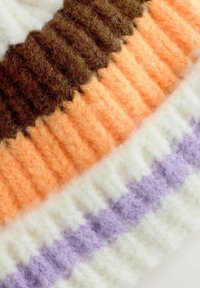 Texturovaný pletený materiál s střídajícími se pruhy hnědé, oranžové, krémové a levandulové barvy, s jemným a nadýchaným vzhledem.