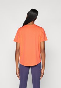 Short-sleeve orange t-shirt with a rounded hem, made from smooth fabric, featuring a crew neckline and minimal seams.