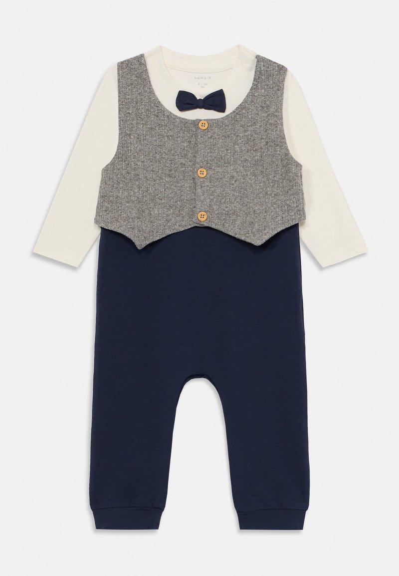 Σκούρο μπλε ολόσωμο με γκρι επικάλυψη γιλέκας, που διαθέτει λευκή μακρυμάνικη μπλούζα, τρία ξύλινα κουμπιά και μια μικρή λεπτομέρεια με παπιγιόν.