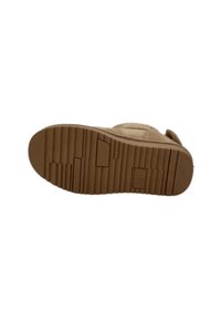 Suela de goma marrón con múltiples patrones texturizados y surcos, diseñada para ofrecer tracción y durabilidad, con un detalle de logo rectangular.