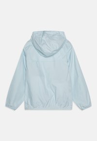 Lys blå vindjakke med hette, elastiske mansjetter og strammet nedre kant. Glatt, vannavstøtende materiale med minimalistisk design.