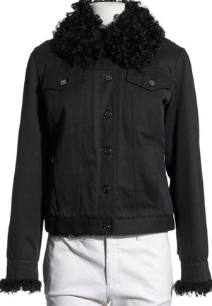 Chaqueta negra con botones, con cuello y puños de piel rizada, llevada sobre pantalones blancos en un maniquí sobre un fondo blanco.