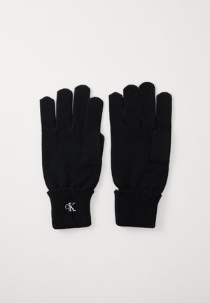 Black knit gloves with five fingers, ribbed cuffs, and a small "cK" logo in white on the wrist area. Soft texture and fitted design.