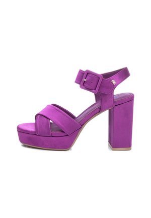 Lilla højhælede plateau sandal med krydssøm, ankelrem med stor spænde og chunky blokhæl.